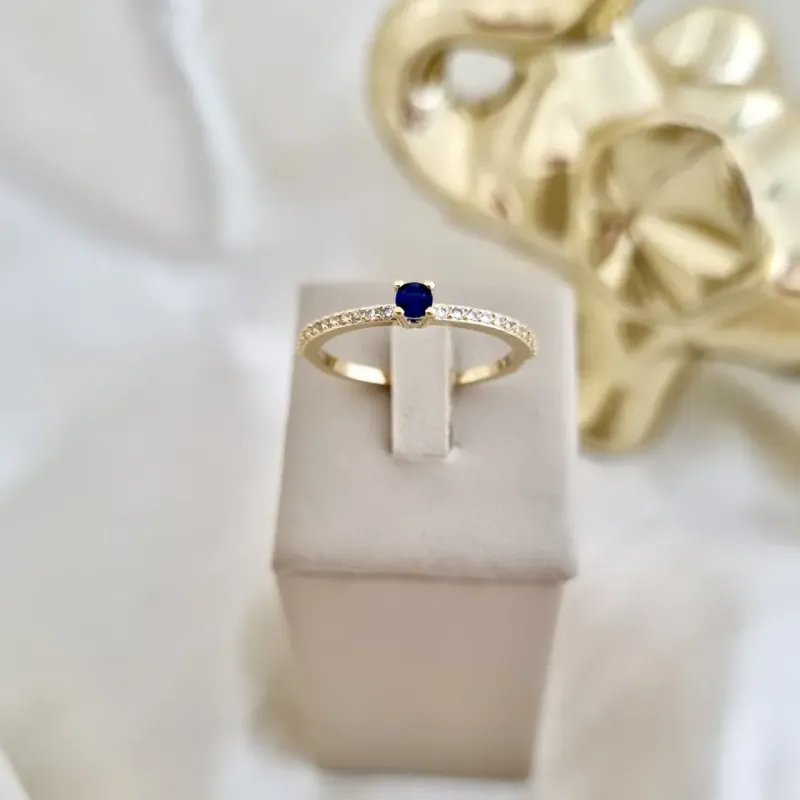 Anel solitário de zircônia azul e aro cravejado em zircônia