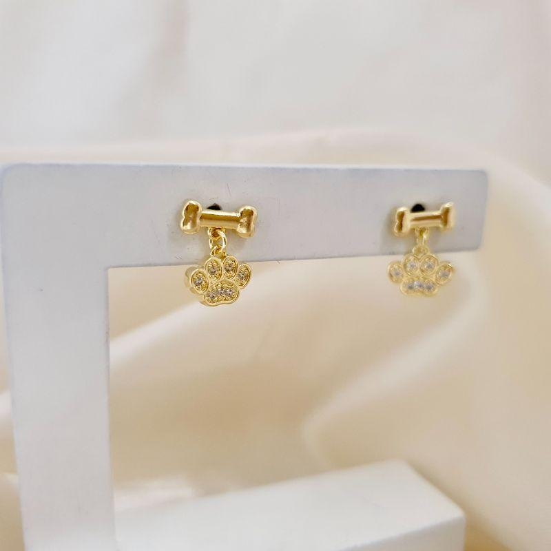 Brinco osso pingente patinha zirconias