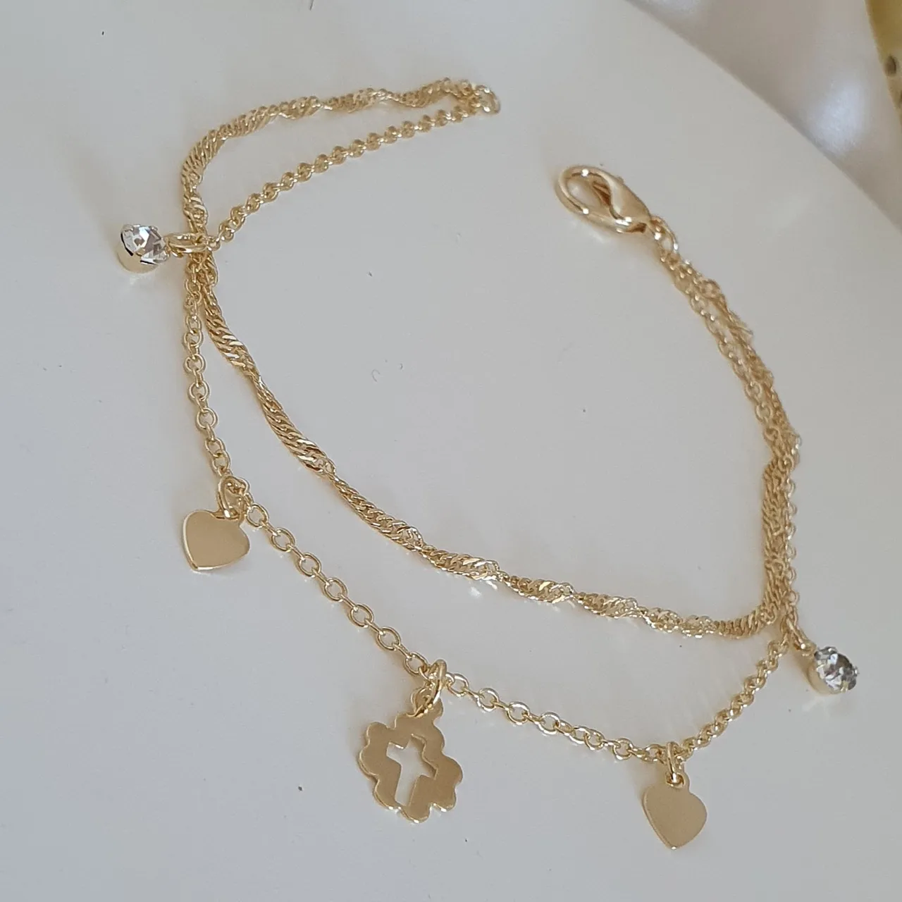 Pulseira dupla com pingentes de cruz, coração e ponto de luz