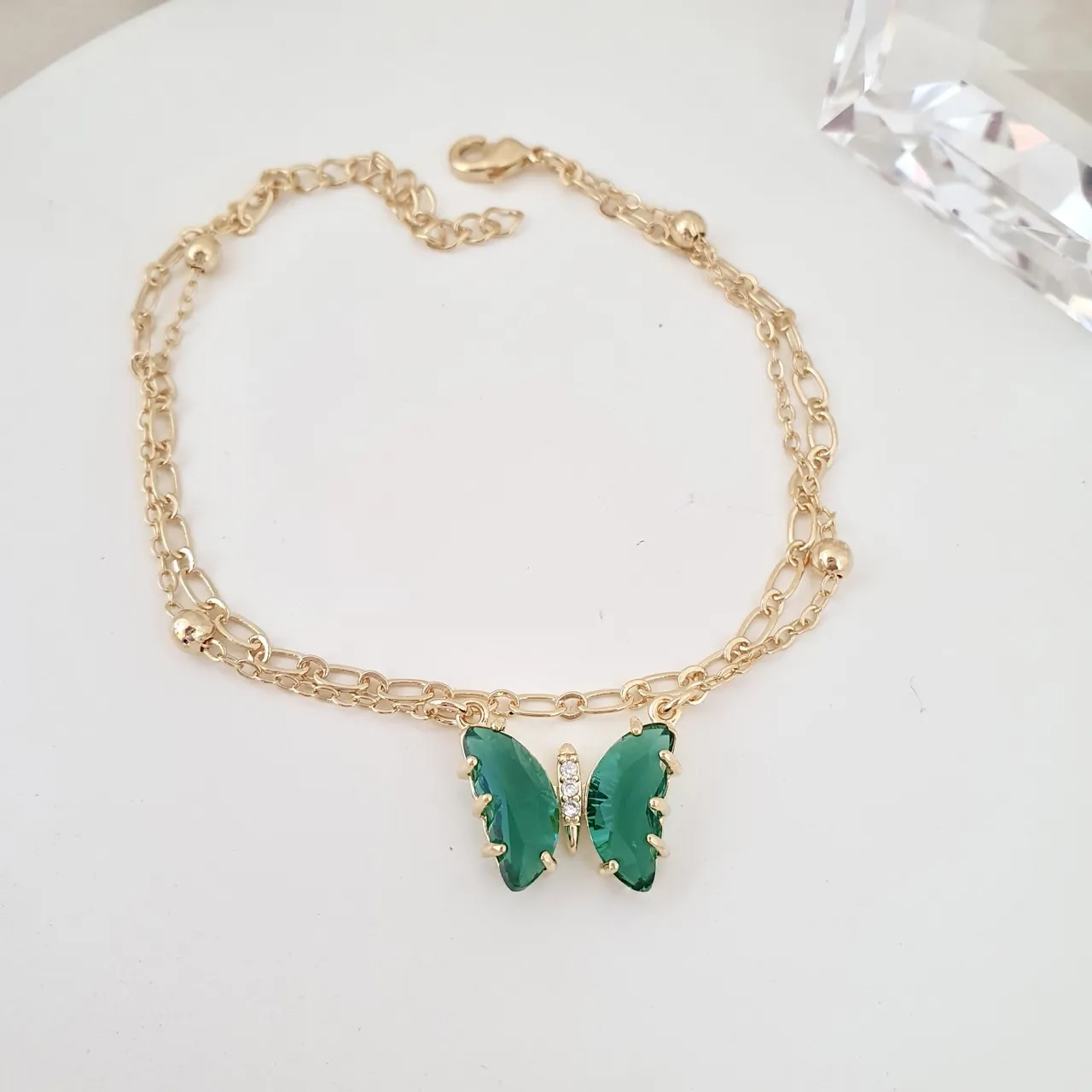 Pulseira dupla com borboleta de zircônia verde