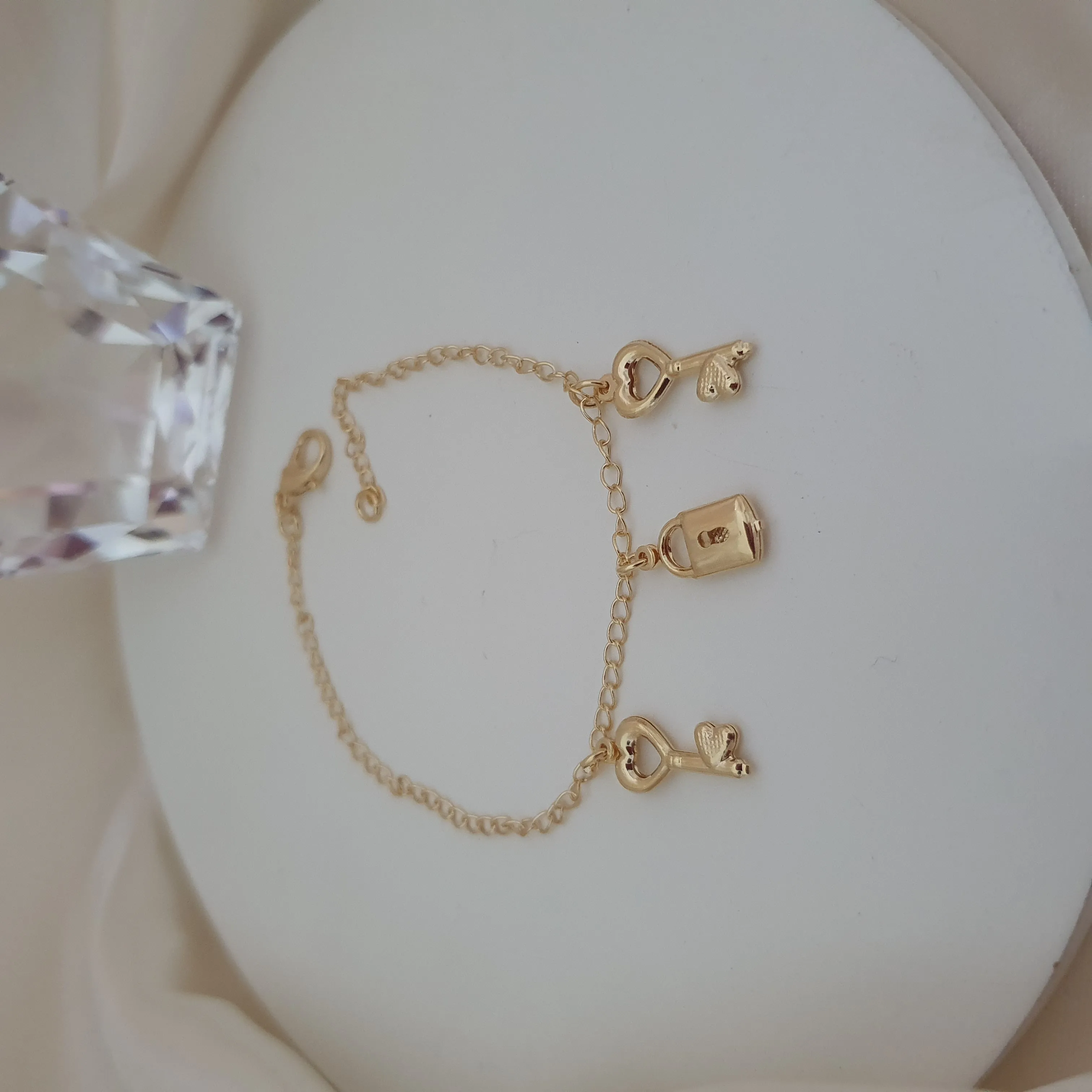 Pulseira com pingente de chave e cadeado com detalhe de coração