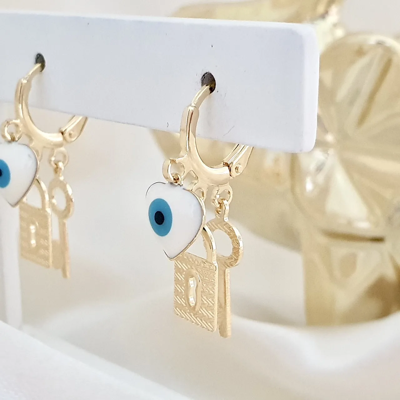 Brinco argola com pingentes olho grego, cadeado e chave