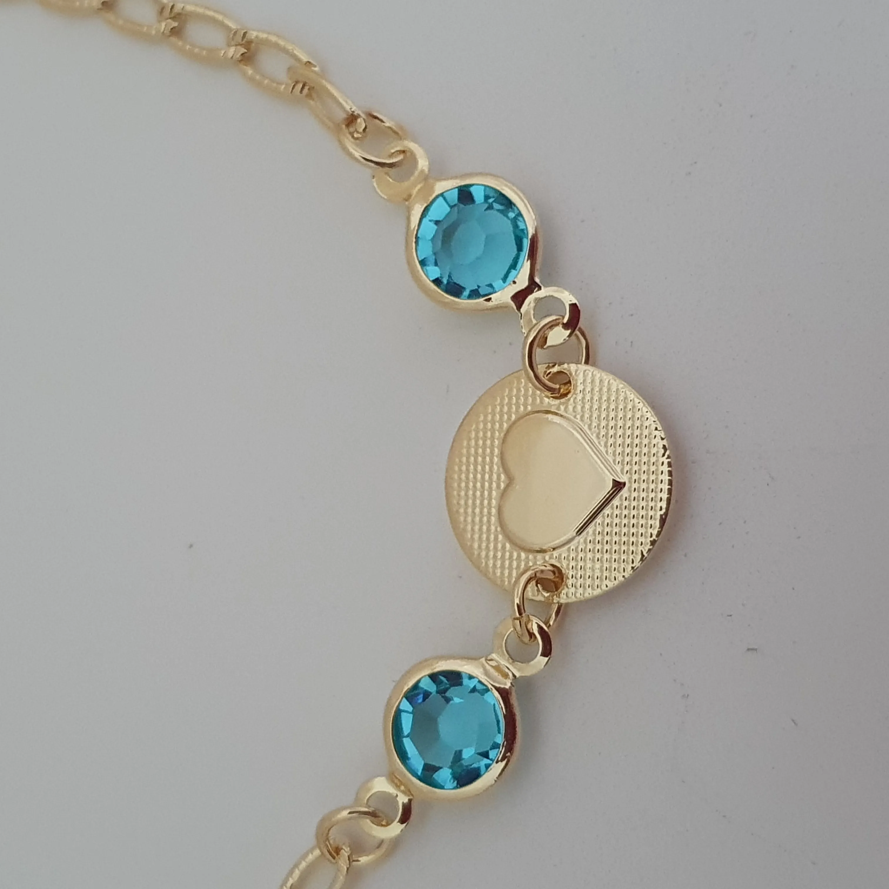 Pulseira com medalha de coração e dois cristais azuis