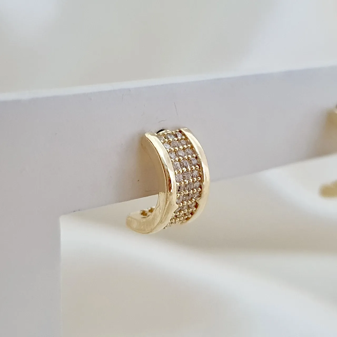Brinco meia argola cravejada com zircônia