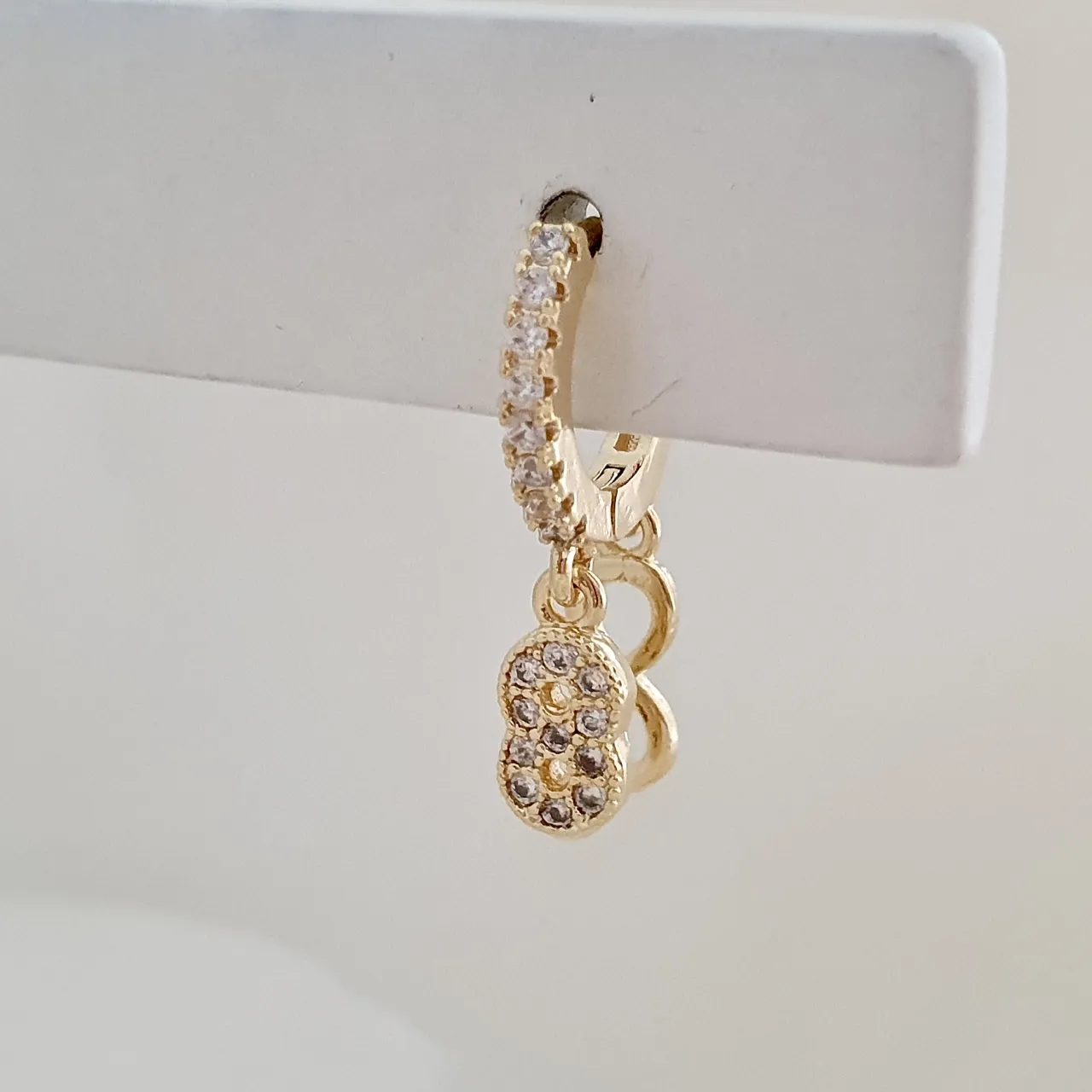Brinco argola click com pingente infinito cravejado de zircônia
