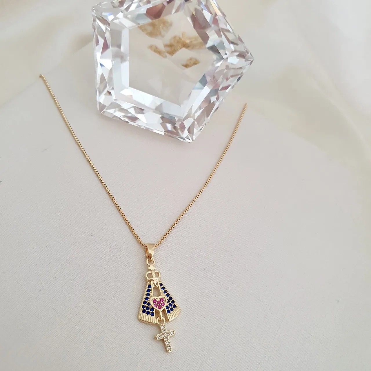 Colar com pingente de Nossa Senhora cravejado com zircônias azuis, rosa e cor cristal