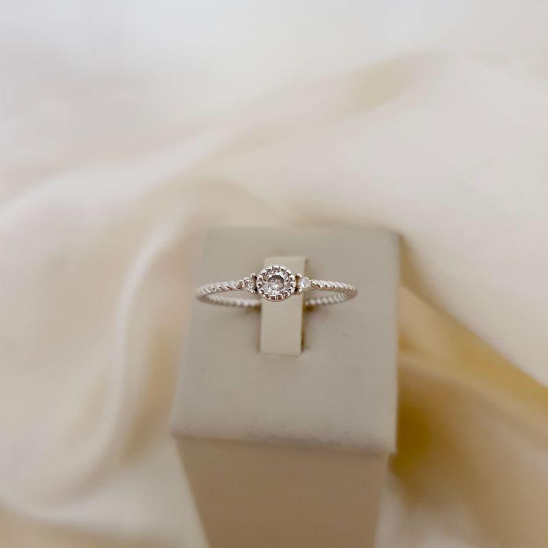 Anel ródio ponto de luz zirconia e 2 menores com aro trançado